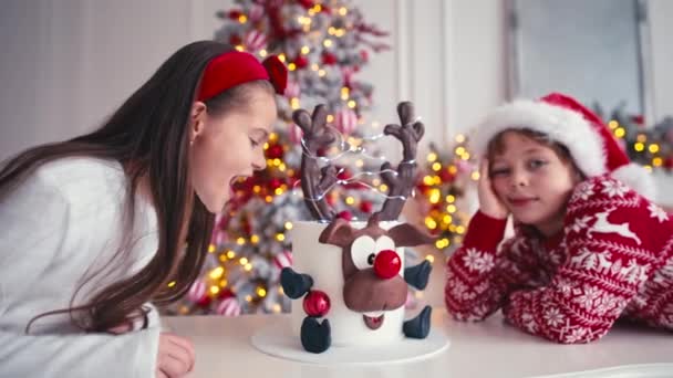 Two caucasian kids boy and girl are sitting near the Christmas cake. Boy waiting for christmas to eat cake — Stock Video