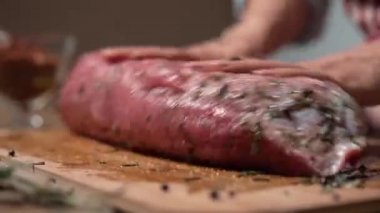 Aşçı kadın bifteğe yağ ve baharat döküyor. Üst düzey gıda hazırlama süreci konsepti. Biftek..