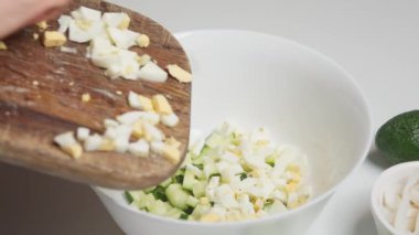 Kadın ev yapımı sebze salatası pişirmek için kesim tahtasında sebze kesiyor..