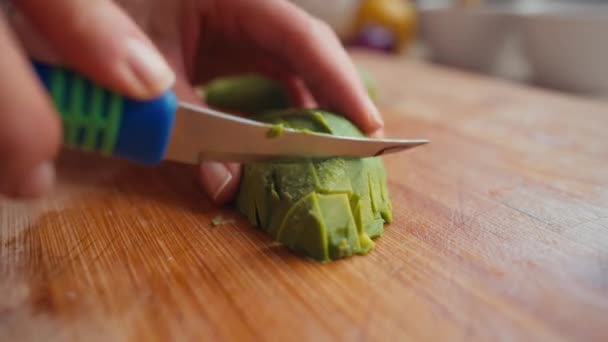 Unrecognizable woman preparing vegetable salad, sustainable lifestyle. Female hands chopping avocado — Stockvideo