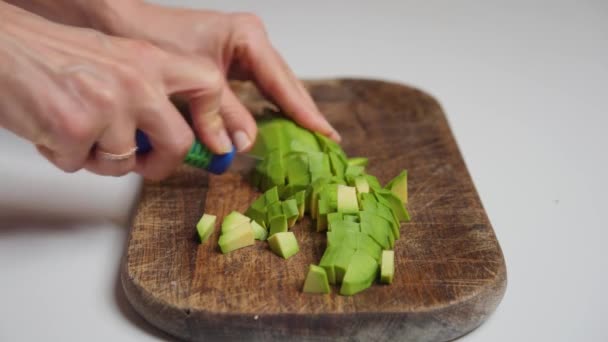 Unrecognizable woman preparing vegetable salad, sustainable lifestyle. Female hands chopping avocado — Wideo stockowe
