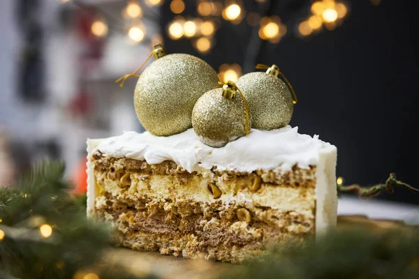 A slice of a cake on a background of christmas lights. — стоковое фото