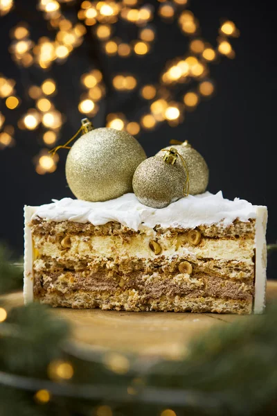 A slice of a cake on a background of christmas lights. — стоковое фото
