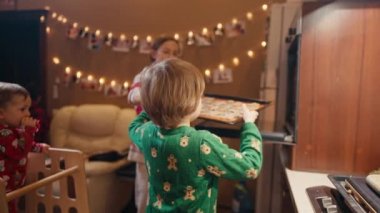 Noel günü evde anneleriyle kurabiye yapan sevimli çocuklar.