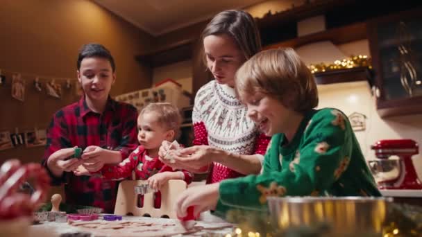 Rodzina z trójką dzieci gotujących imbirowe ciasteczka. Wesołych Świąt, szczęśliwego Nowego Roku. Czas rodzinny, przygotowanie do wakacji. — Wideo stockowe