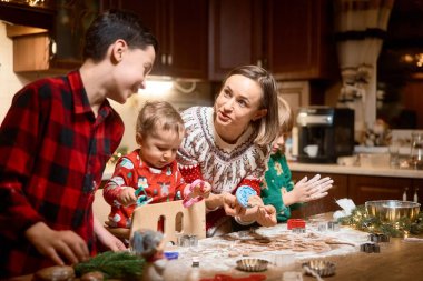 Noel günü evde anneleriyle kurabiye yapan sevimli çocuklar.