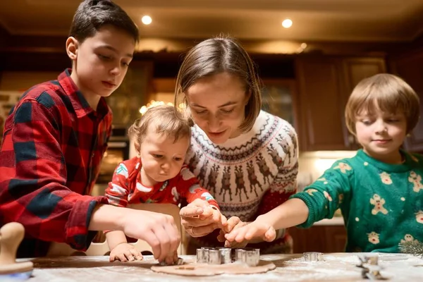 Cute children making cookies with mother on Christmas Day at home — стоковое фото