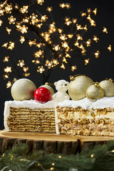 A slice of a cake on a background of christmas lights. — стоковое фото