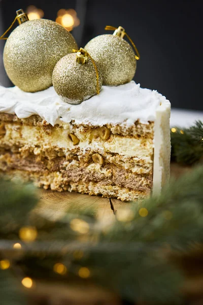 A slice of a cake on a background of christmas lights. — стоковое фото