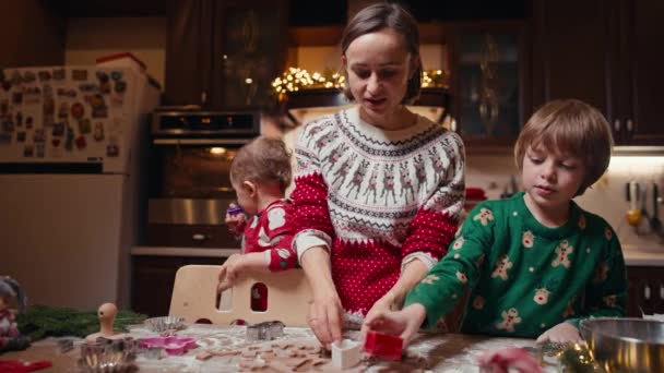 Leuke kinderen maken koekjes met moeder op kerstdag thuis — Stockvideo