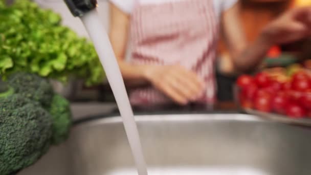 Mujer lavando pimiento rojo bajo agua del grifo. — Vídeos de Stock