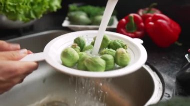 Brüksel lahanalarını kadın ellerinde yıkamak. Sağlıklı beslenme kavramı. 