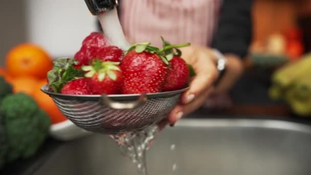 Kvinnliga händer tvättar jordgubbar i köket. Långsam rörelse skott. — Stockvideo