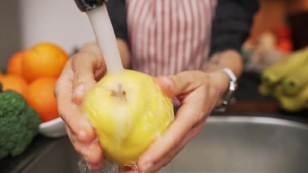 Mujer sosteniendo fruta de membrillo en las manos lavándola y limpiándola bajo el agua. Nutrición saludable. — Vídeos de Stock