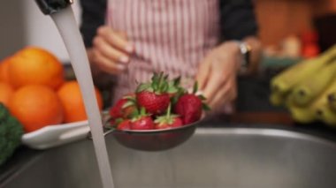 Kadın elleri mutfakta çilek yıkıyor.. 