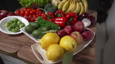 Karanlık mutfak masasında taze meyve ve sebzeler. Vejetaryen yemekleri için çeşitli sebzeler. Çekimin üstünde