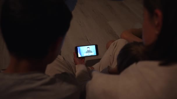 KIEV, UKRAINE FEBRUARY 5th 2022 - Family watching the speech of the President of Ukraine Volodymyr Zelensky on smartphone. News about war between Ukraine and Russia. Russian aggression. — Stock Video