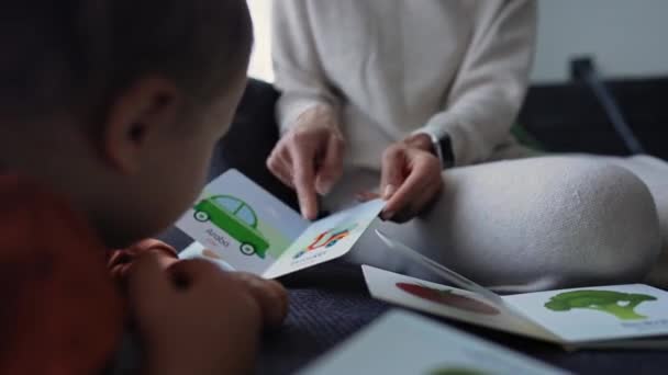 A 1 year old boy with his mum at home. Mom learning new words with baby. Child development, education. — Stock Video