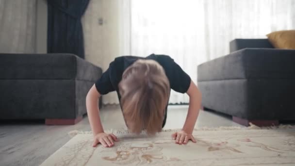 Der Junge schiebt sich zu Hause vom Boden nach oben. Quarantäne und Sportkonzept. Das Kind entwickelt Willenskraft und Modus — Stockvideo