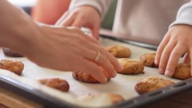 Elleri fırın tepsisinden taze sıcak kurabiye alır. Kadınlar, erkekler ve çocuk elleri taze ev kurabiyeleri alır. Birçok el birer birer kurabiye alır. Tatlı bir aile yemeği..