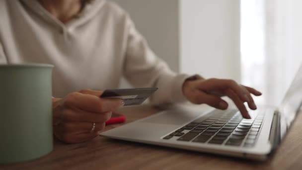 Irritée jeune fille caucasienne assis avec ordinateur et carte de crédit sur le canapé dans la salle de cuisine, ne peut pas faire d'achat, pas assez d'argent. Client mécontent insatisfait des services bancaires de paiement en ligne — Video