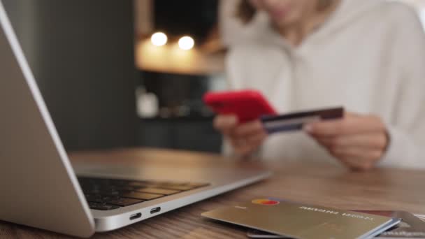 Irritée jeune fille caucasienne assis avec ordinateur et carte de crédit sur le canapé dans la salle de cuisine, ne peut pas faire d'achat, pas assez d'argent. Client mécontent insatisfait des services bancaires de paiement en ligne — Video