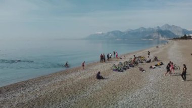 Triatlon eğitiminin sabah deniz kıyısında havadan çekimi. Bir grup genç sporcu suyu istila ediyor. Denizde ya da okyanusta yüzmeye başla.