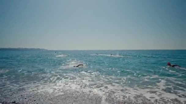 ANTALYA, TURQUIA - 15 de abril de 2022: Tiro de treinamento de Triatlo na costa do mar pela manhã. Um grupo de jovens atletas invade a água. Comece a nadar no mar ou no oceano — Vídeo de Stock