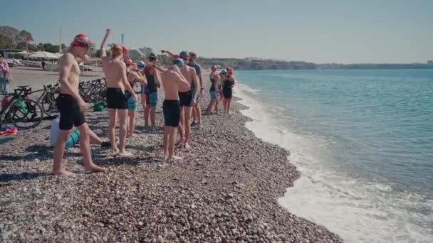 ANTALYA, TURKEY APRIL 15, 2022: Ditembak Triathlon pelatihan di pantai laut di pagi hari. Sekelompok atlet muda dekat air. Mulai berenang di laut atau laut — Stok Video