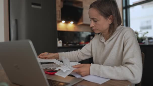 Young woman getting stressed over finances. Young woman looking worried over bills in kitchen. Working from home in quarantine lockdown. Social distancing Self Isolation. — Stock Video