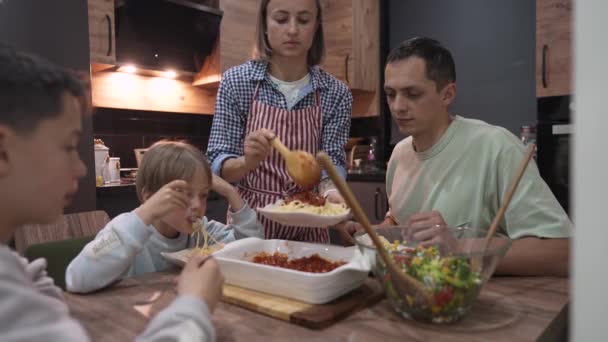 Fiatal boldog család beszél vacsora közben otthon asztalnál — Stock videók