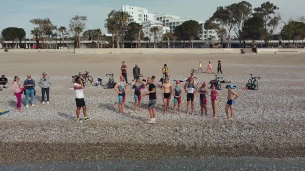 ANTALYA, TURQUÍA - 15 DE ABRIL DE 2022: Aerial Shot of Triathlon training on sea shore in the morning. Un grupo de jóvenes atletas invade el agua. Empieza a nadar en el mar o en el océano — Vídeos de Stock