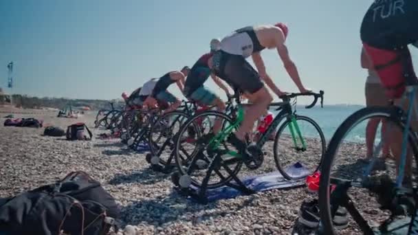 ANTALIA, TURCHIA - 15 APRILE 2022: Colpo di Triathlon sulla riva del mare al mattino. Un gruppo di giovani atleti si allena in bicicletta — Video Stock