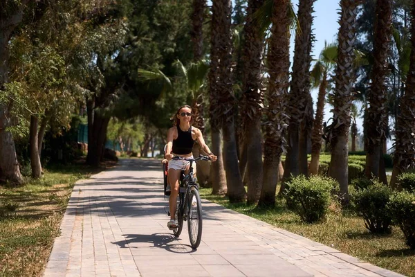 Küçük oğluyla bisiklete binen genç bir kadın.