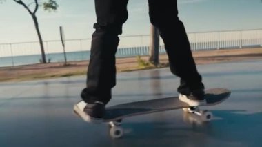 Caddede kaykay yapmak. Otantik ve modaya uygun kaykaycıların sinematik yakın çekimleri sıcak yaz akşamlarında Kaliforniya 'da günbatımında gezinti yapmaktadır. Açık hava aktivitesi.