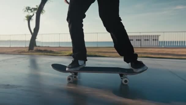 Skateboarding on Street. Slow motion cinematic close up of authentic and trendy skateboarder stroll through sunset filled california vibes promenade on warm summer evening. Outdoors activity. — Stockvideo