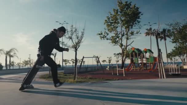 Skateboarder em um parque de atletismo. Skateboarder praticar em um parque de pista bomba em um dia ensolarado de verão — Vídeo de Stock