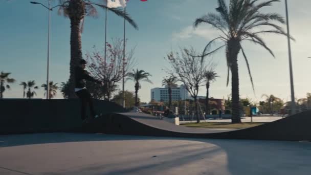 Skateboarding on Street. Slow motion cinematic close up of authentic and trendy skateboarder stroll through sunset filled california vibes promenade on warm summer evening. Outdoors activity. — Stock videók