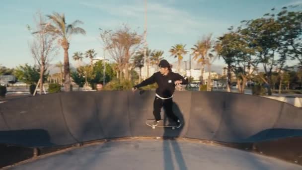 Skateboarder su una pista di pompaggio. Pratica dello skateboarder su un parco di piste di pompaggio in una giornata estiva soleggiata — Video Stock
