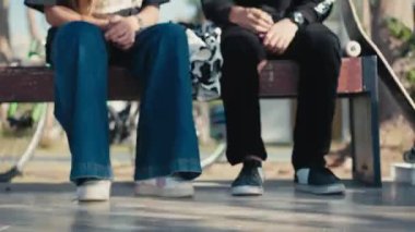 Birkaç genç kaykaycı kahve içmek için durakladı. Kaykayın üstünde iki fincan kahve. Yaşam tarzı, bağbozumu, arkadaşlık kavramı. Yüksek kalite 4k görüntü.