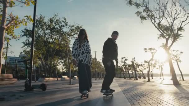 ヒップスターカップルスケートボード。若いカップルのスケートボードの通りです。ビーチでスケートボードを楽しんでいるカップル — ストック動画