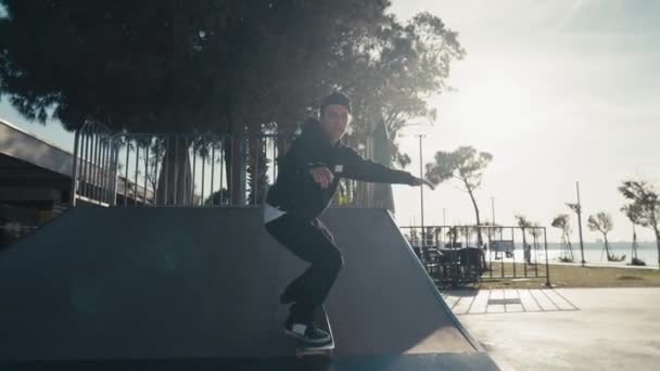 スケートパークで練習しているスケーターの少年。スケートボードパークでスケートボードのトリックをやっている若い男. — ストック動画