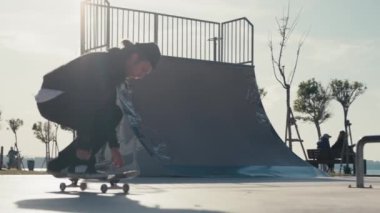 Adam rampada kayıyor. Beton Kaykay Parkı 'nda Atlayan Kaykaycı.