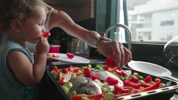 Mutter bringt ihrem kleinen Sohn in der Küche das Kochen von gesundem Essen bei. Lebensstil mit Kaukasiern in Alleinerziehenden-Familien. Kind hilft Mutter in Küche — Stockvideo