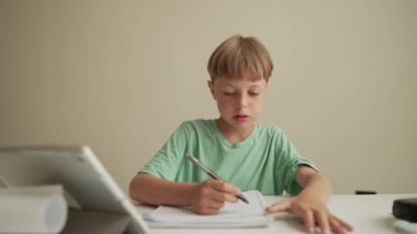 Otantik Çocuk evde arkadaşlarıyla online ödev yapıyor, Çocuk evde öğrenim için tablet kullanıyor, Okul çocuğu öğretmenle online zoom video çalışması yapıyor, E-öğreniyor ya da evde eğitim kavramı geliştiriyor.