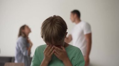 Çocuğun oğlu arka planda kavga ederken üzgün hissediyor, anne ve babasının tartışması yüzünden hayal kırıklığına uğrayan üzgün küçük kız, aile içi anlaşmazlıklar ya da çocuk konsepti üzerindeki boşanma etkisi.