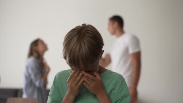 Kid son feels upset while parents fighting at background, sad little girl frustrated with psychological problem caused by mom and dad arguing, family conflicts or divorce impact on child concept. — Stock Video