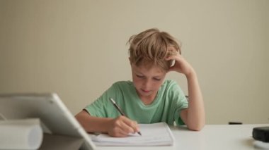 Otantik Çocuk evde arkadaşlarıyla online ödev yapıyor, Çocuk evde öğrenim için tablet kullanıyor, Okul çocuğu öğretmenle online zoom video çalışması yapıyor, E-öğreniyor ya da evde eğitim kavramı geliştiriyor.