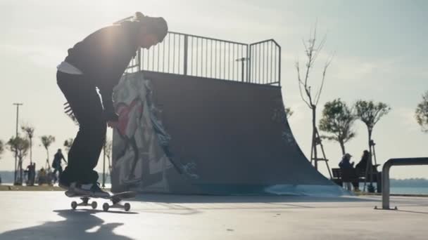 El tipo patina en una rampa. Skateboarder haciendo un salto en un parque de patinaje concreto. — Vídeos de Stock