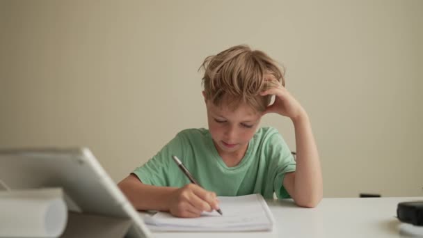 Authentic Kid fazendo lição de casa on-line com amigos em casa, Criança usando tablet para aprendizagem em casa, Menino da escola estudando zoom online chamada de vídeo com professor, E-learning ou conceito de educação Homeschooling — Vídeo de Stock